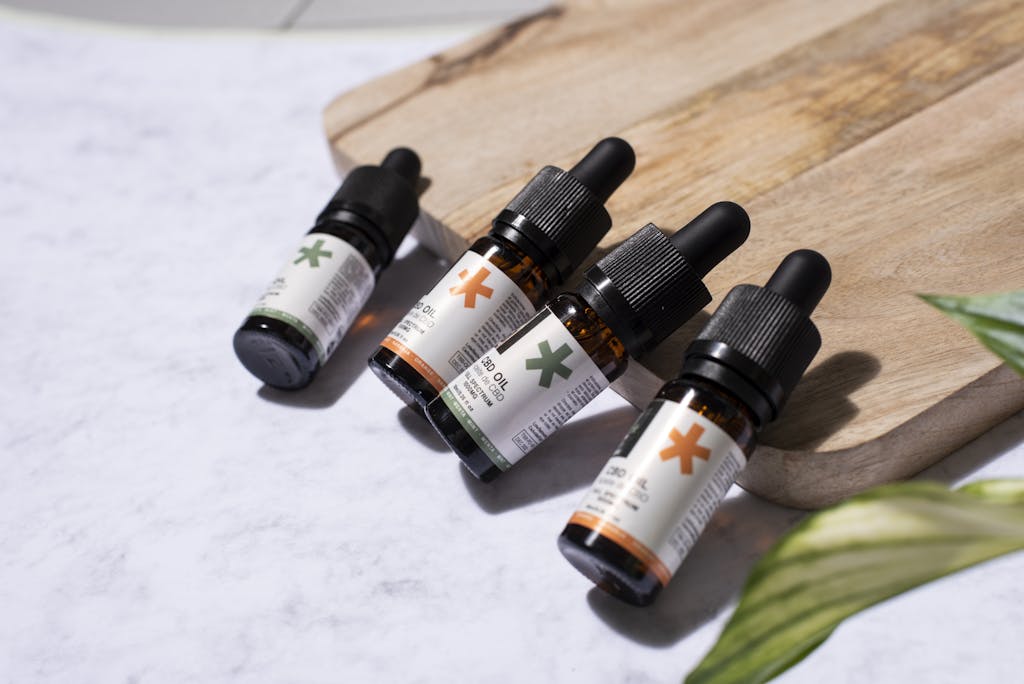 CBD oil bottles arranged on a wooden board with a natural leaf, perfect for holistic product promotion.